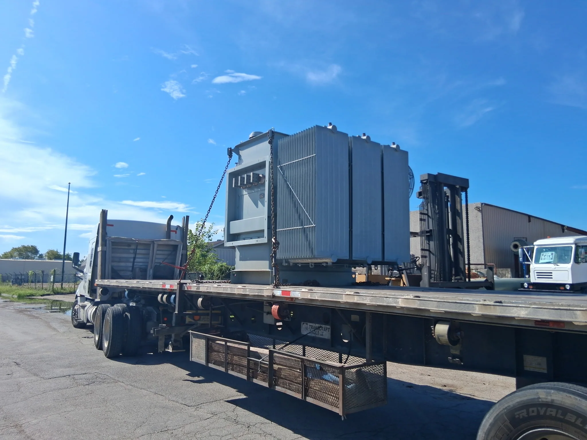 Large electrical transformer secured on a flatbed trailer